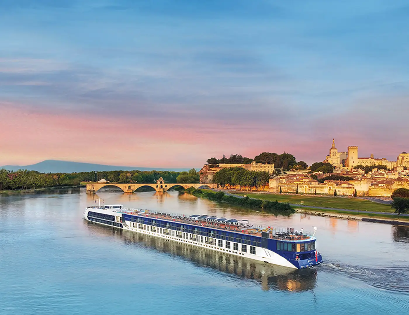 An Adventures by Disney river cruise ship sailing past a European riverside town