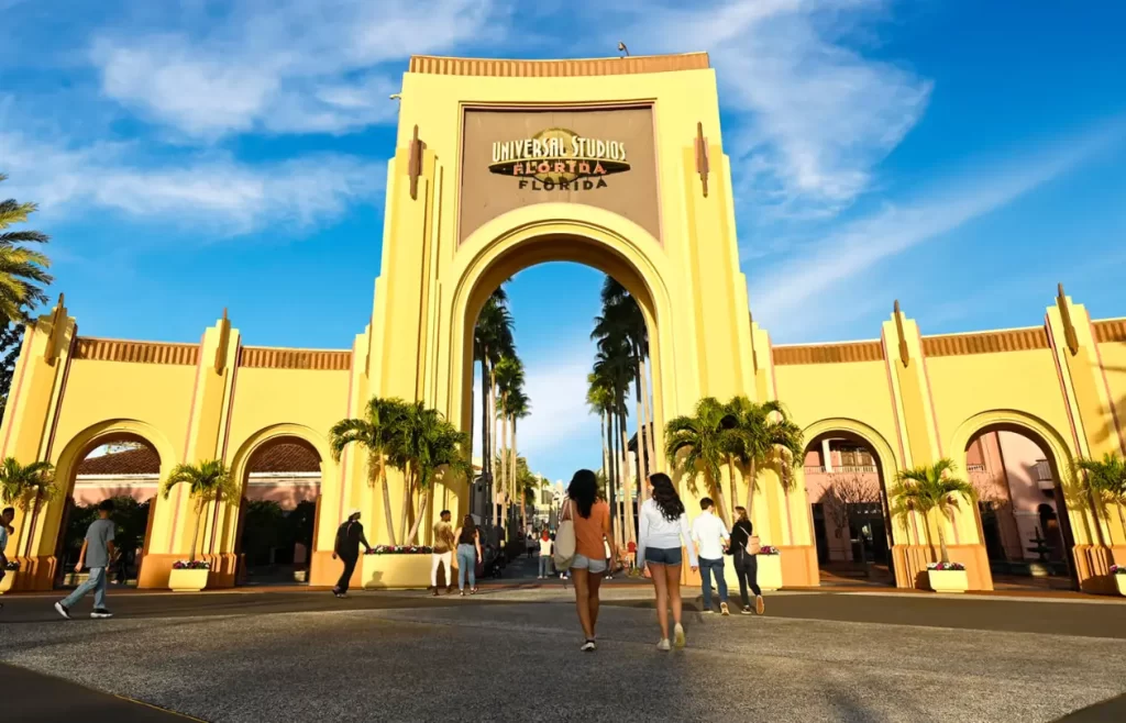 Guests walking through the Universal Studios Florida entrance arch
